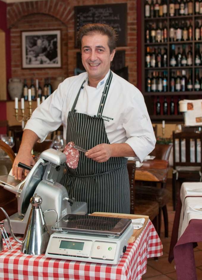 Stavros schneidet Wurst an der Schneidemaschine